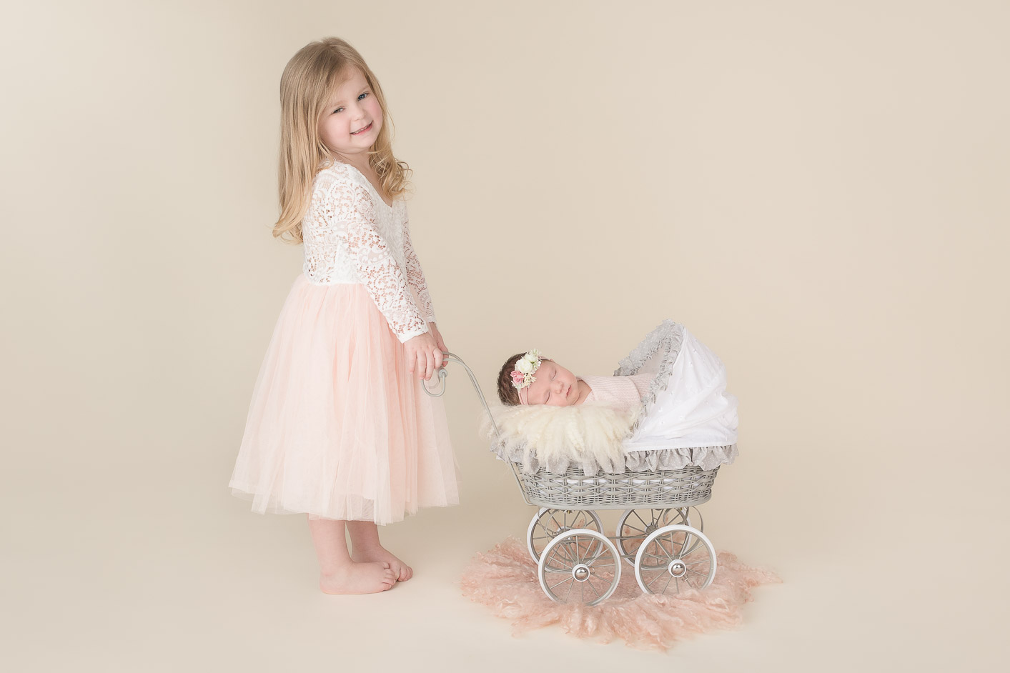 Young girl posed with newborn sister in carriage