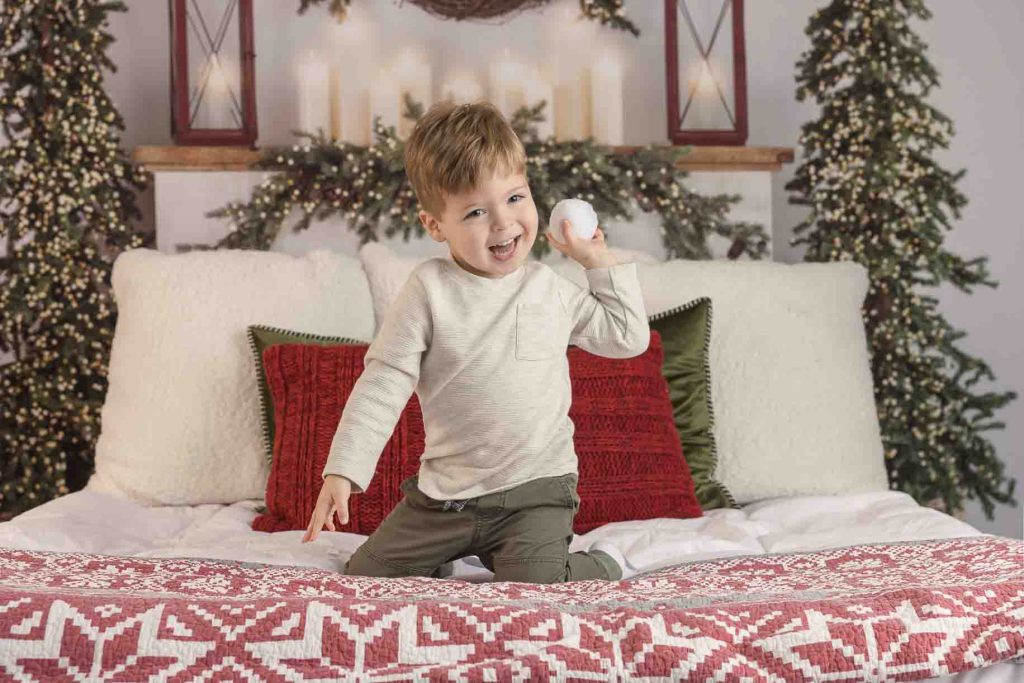 Boy getting ready to throw a snowball during his Christmas portraits.